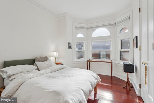 bedroom with crown molding and dark hardwood / wood-style flooring