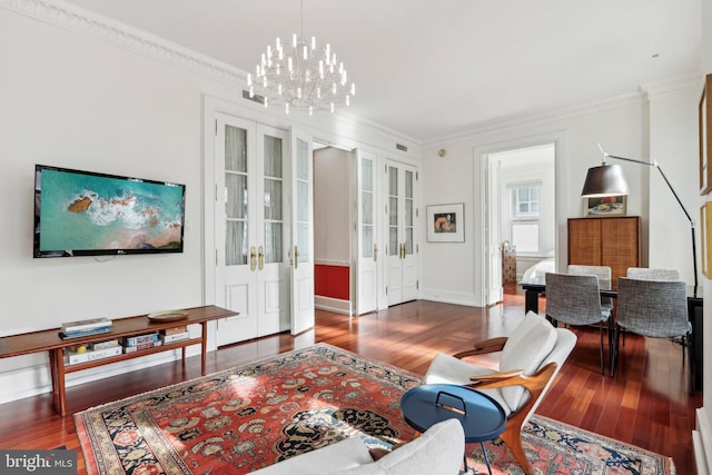 living room with crown molding, dark wood-type flooring, a chandelier, and french doors