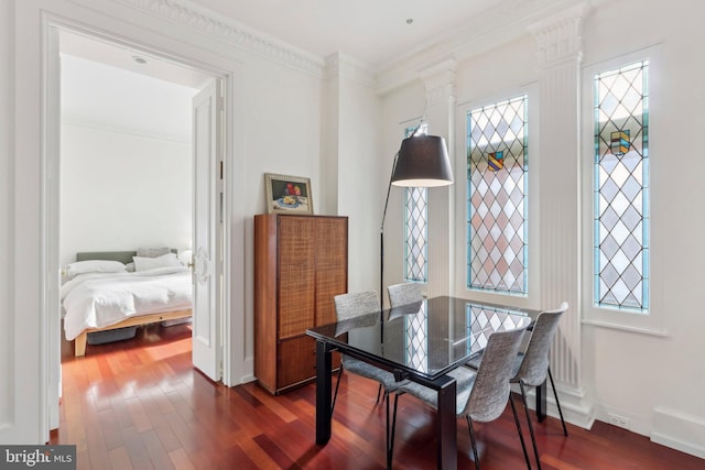 dining area featuring decorative columns, dark hardwood / wood-style floors, and crown molding