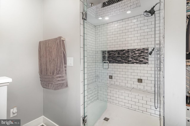 full bath featuring a shower stall and baseboards