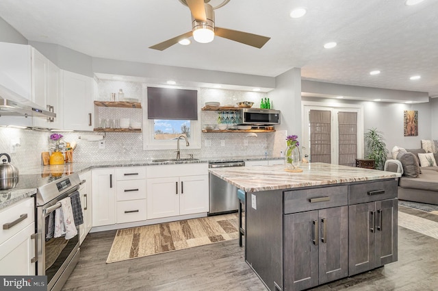 kitchen with open shelves, appliances with stainless steel finishes, a sink, and white cabinets