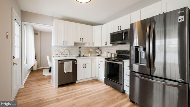 kitchen with sink, white cabinets, appliances with stainless steel finishes, and tasteful backsplash