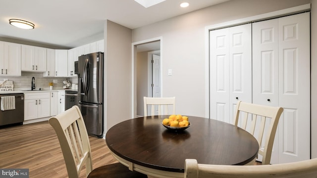 dining space with light hardwood / wood-style floors and sink