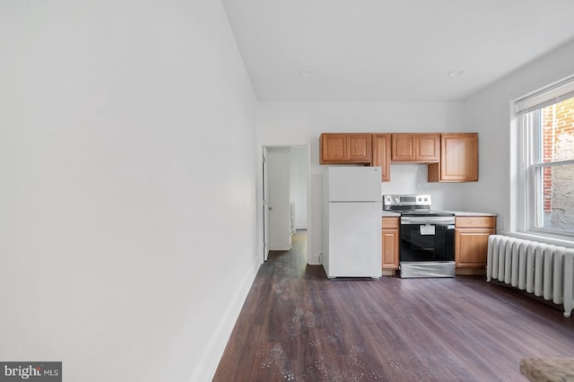 kitchen featuring white fridge, radiator, stainless steel electric range, and dark wood-type flooring