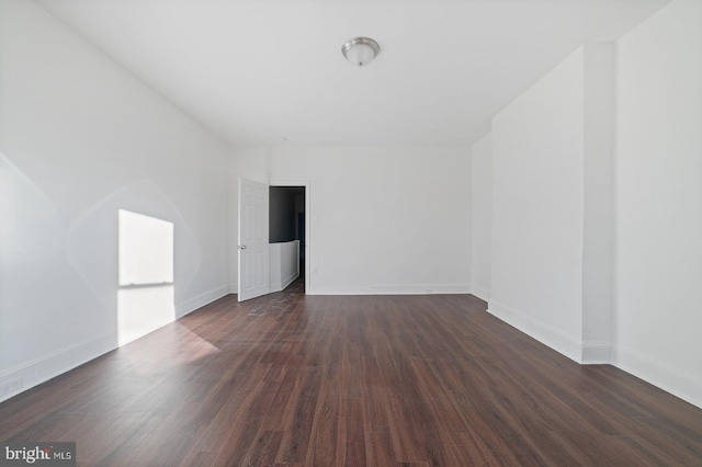 unfurnished room featuring dark wood-type flooring