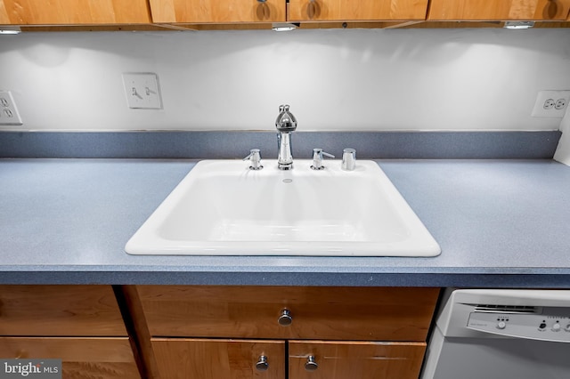 interior details featuring light countertops, brown cabinets, a sink, and dishwashing machine