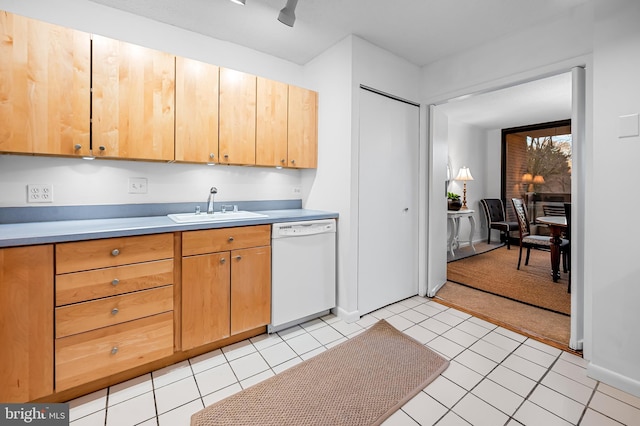 kitchen featuring light countertops, white dishwasher, a sink, and light tile patterned floors