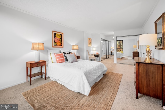 bedroom with light carpet, baseboards, and two closets