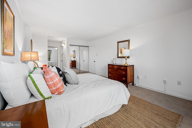 bedroom with a closet, light carpet, and baseboards