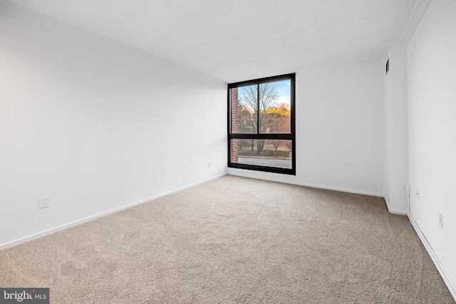 empty room with baseboards and light colored carpet