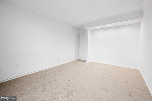 spare room with light carpet, baseboards, and crown molding