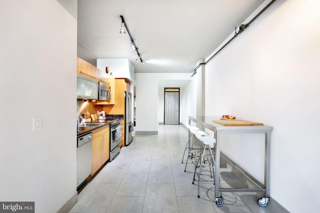 kitchen with sink, stainless steel appliances, and rail lighting