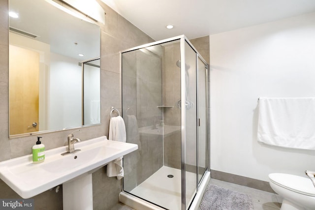 bathroom with sink, toilet, and a shower with shower door