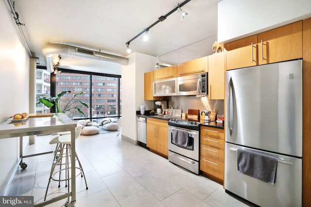 kitchen with rail lighting, sink, and appliances with stainless steel finishes