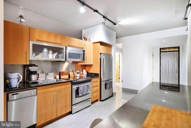 kitchen with sink, light tile patterned floors, stainless steel appliances, and track lighting