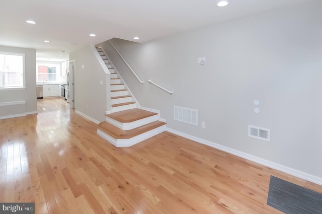 stairs with sink and hardwood / wood-style floors