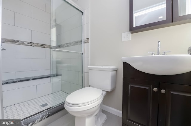 bathroom with toilet, a shower with shower door, and vanity