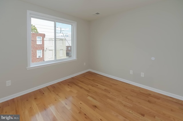 spare room featuring plenty of natural light and light hardwood / wood-style flooring