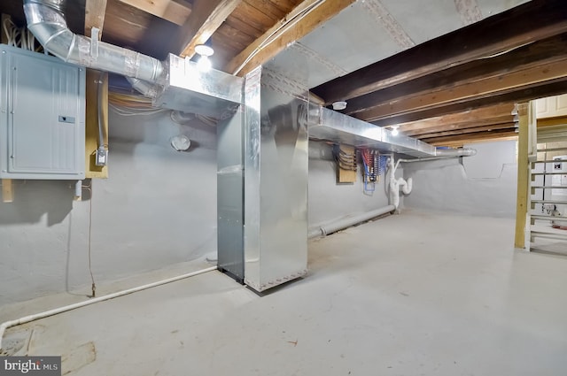 basement featuring electric panel and heating unit