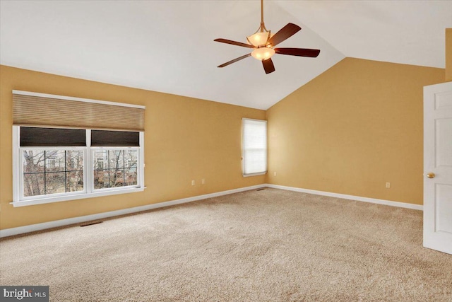 carpeted spare room featuring lofted ceiling, visible vents, a ceiling fan, and baseboards