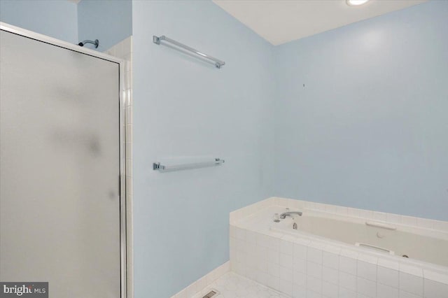 bathroom featuring a shower stall, baseboards, a bath, and tile patterned floors