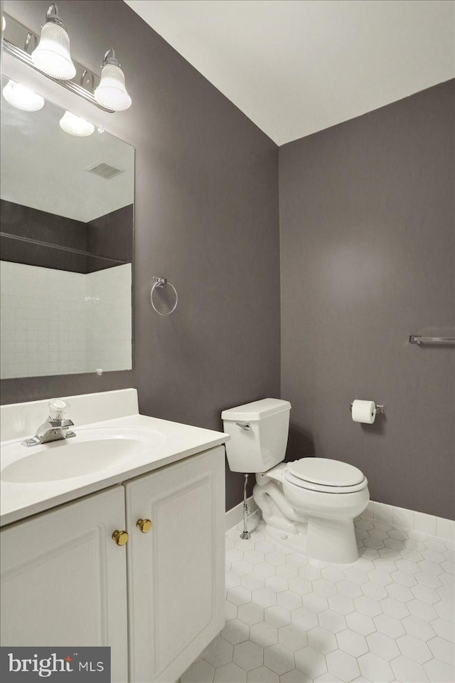 bathroom with baseboards, visible vents, toilet, tile patterned floors, and vanity