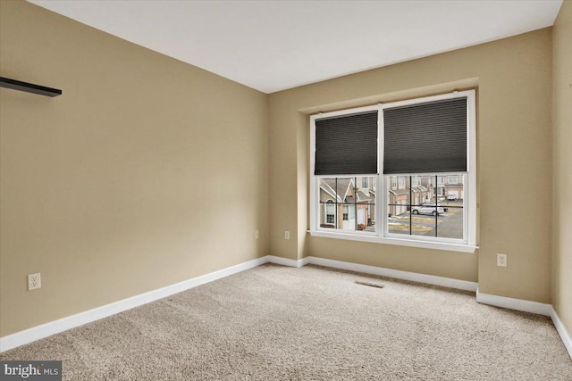 carpeted empty room featuring visible vents and baseboards