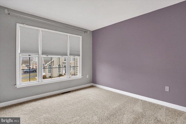 carpeted spare room with visible vents and baseboards