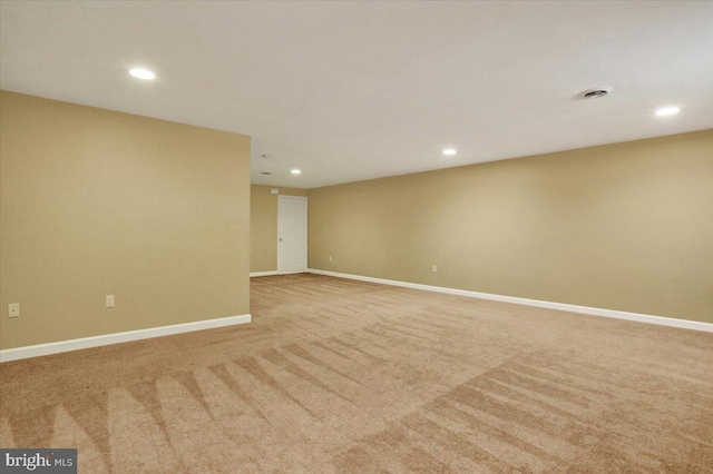 unfurnished room featuring light colored carpet, visible vents, baseboards, and recessed lighting