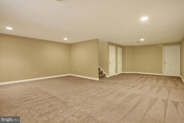 finished below grade area featuring stairway, carpet, and baseboards