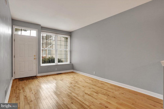 foyer entrance with light wood-style flooring and baseboards