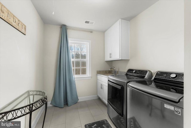 washroom with light tile patterned flooring, cabinets, sink, and washing machine and dryer