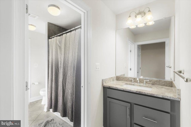 bathroom featuring vanity, tile patterned floors, and toilet