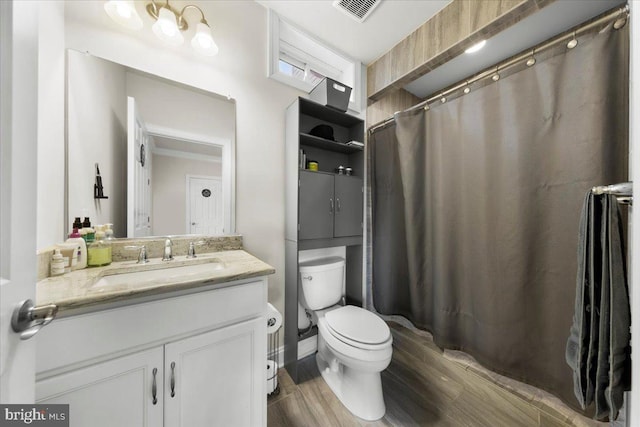 bathroom with vanity, toilet, and hardwood / wood-style floors