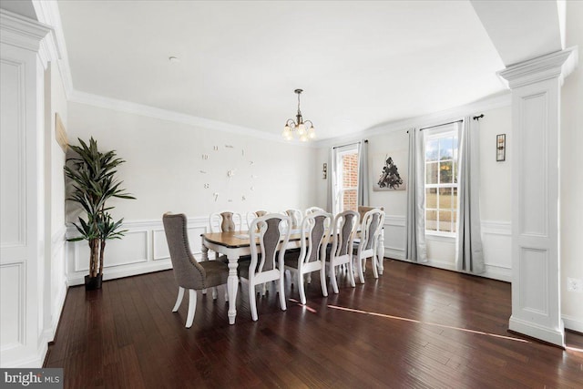 dining space with ornamental molding, dark wood-type flooring, decorative columns, and a chandelier