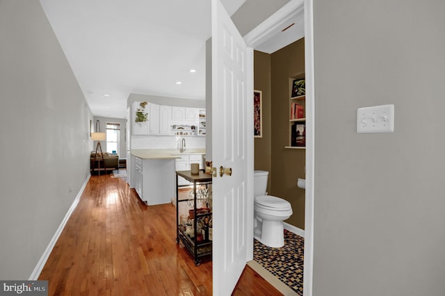 hallway featuring sink and light hardwood / wood-style flooring