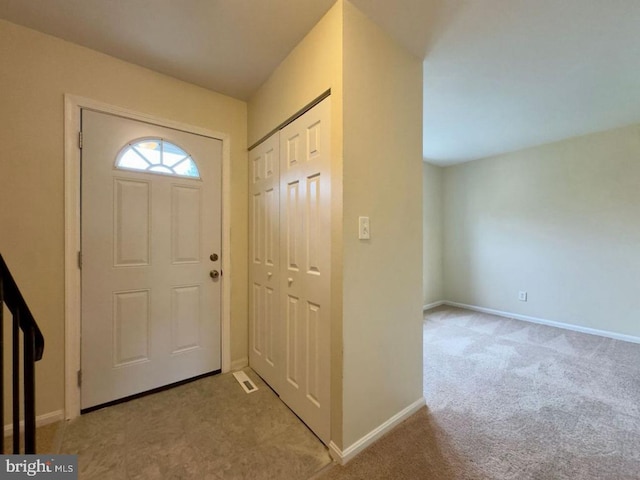 entryway featuring visible vents, baseboards, and light colored carpet