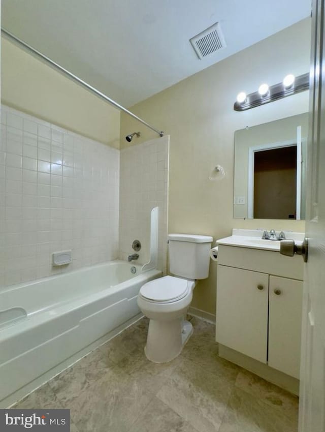 full bathroom featuring vanity, tiled shower / bath combo, and toilet