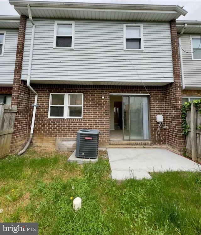 rear view of property featuring a yard, central AC, and a patio area