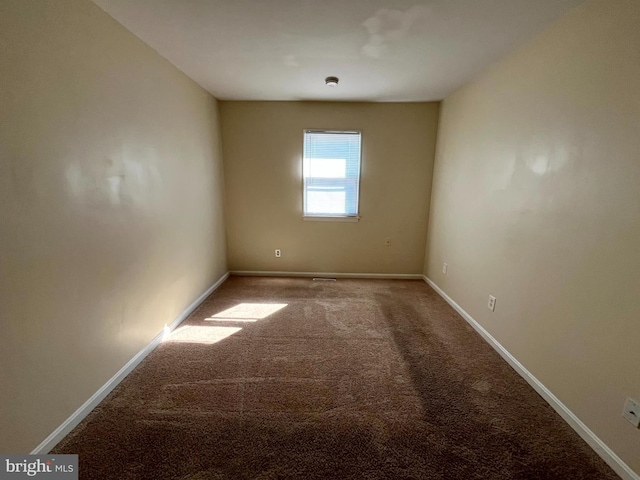 carpeted spare room with baseboards