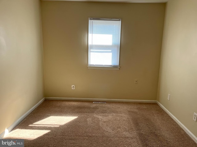 carpeted empty room with visible vents and baseboards