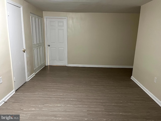 spare room featuring baseboards and wood finished floors