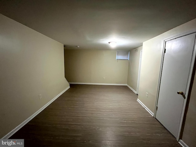 finished below grade area with dark wood-style floors and baseboards