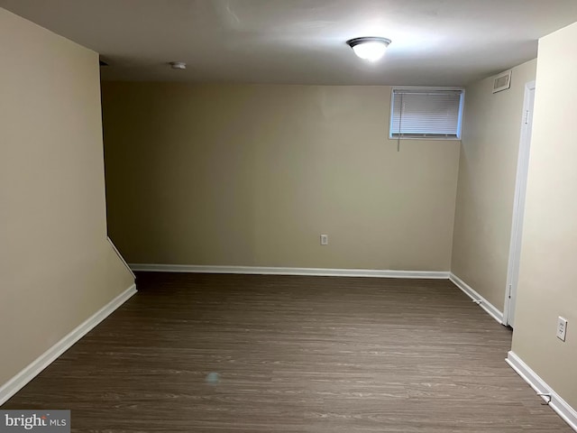 finished below grade area featuring baseboards and dark wood-type flooring