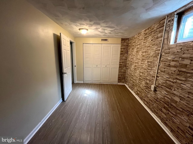 hallway featuring baseboards, visible vents, and dark wood-style flooring