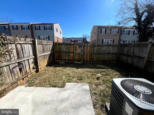 view of yard featuring a residential view, a fenced backyard, and central air condition unit