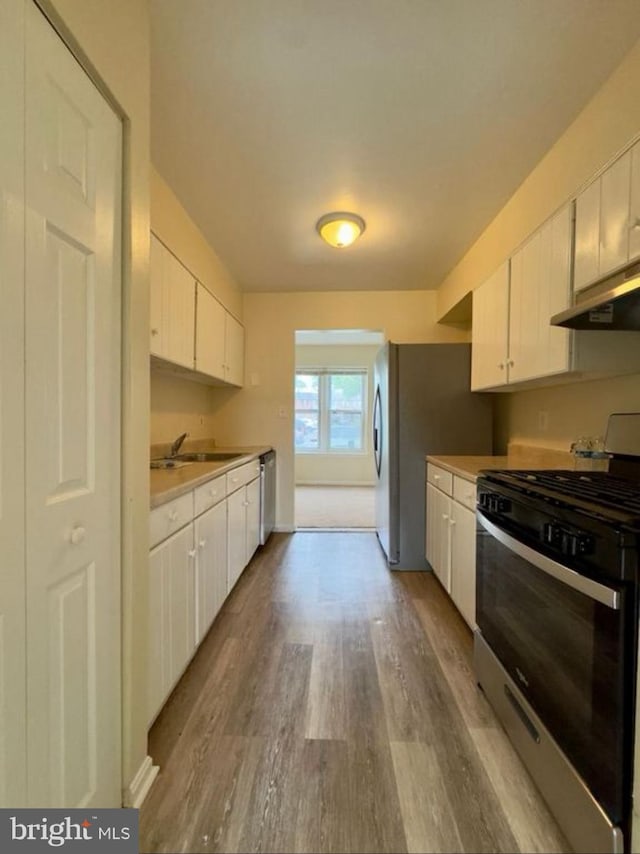 kitchen featuring white cabinetry, sink, hardwood / wood-style flooring, and stainless steel appliances