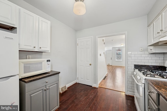 kitchen with dark hardwood / wood-style flooring, white appliances, decorative backsplash, and white cabinets