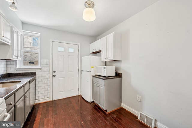 kitchen featuring dark hardwood / wood-style flooring, sink, white appliances, and white cabinets