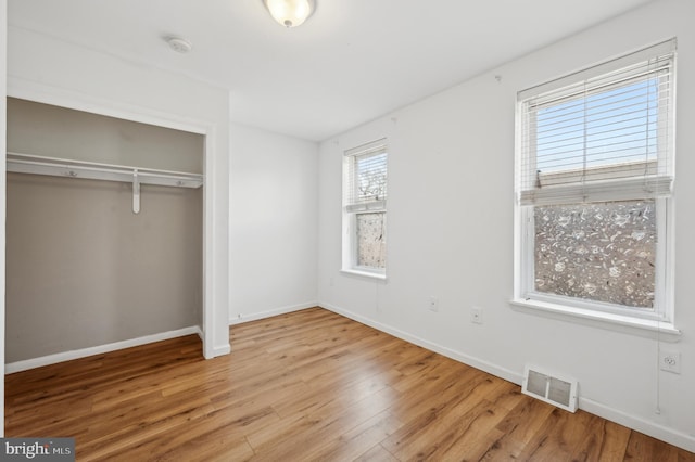 unfurnished bedroom with light hardwood / wood-style flooring and a closet